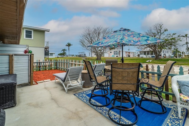 view of patio featuring outdoor dining area and fence