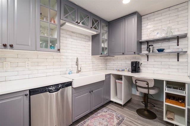 kitchen featuring a sink, backsplash, dishwasher, and gray cabinets