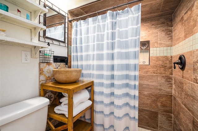 bathroom with toilet and tiled shower