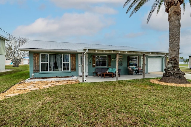 view of front of home with a garage, a porch, metal roof, and a front yard