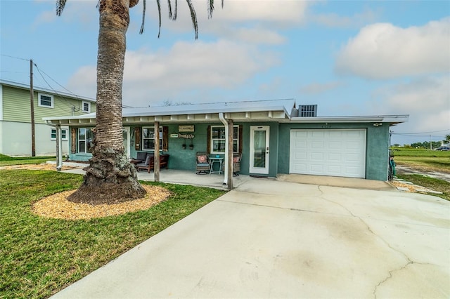 view of front of home featuring concrete driveway, a garage, a front yard, and stucco siding