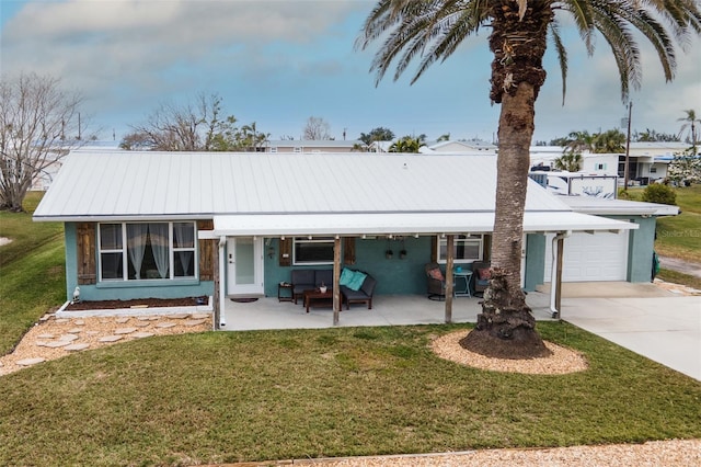 single story home featuring a front yard, concrete driveway, a garage, and stucco siding