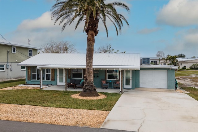 view of front of home with a garage, a front yard, metal roof, and driveway