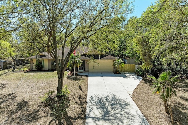 view of front of house featuring a front yard, fence, a garage, and driveway