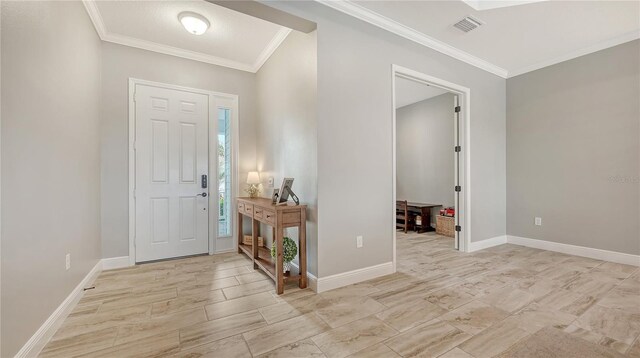 entrance foyer featuring visible vents, crown molding, and baseboards