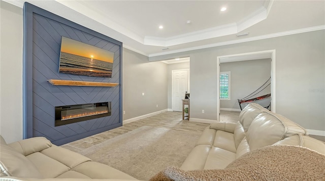 living room featuring a raised ceiling, crown molding, a fireplace, and baseboards