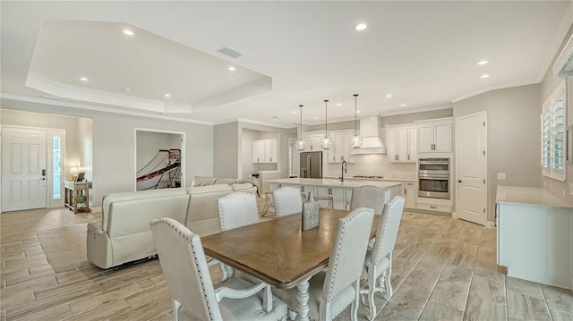 dining area featuring wood finish floors, visible vents, ornamental molding, a tray ceiling, and recessed lighting