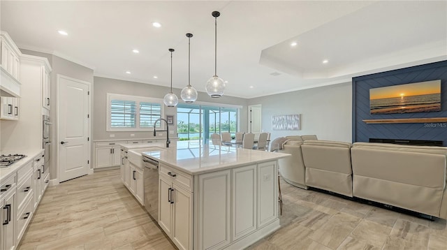 kitchen with light countertops, open floor plan, stainless steel appliances, and a sink