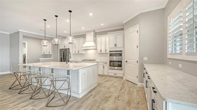 kitchen featuring tasteful backsplash, premium range hood, a kitchen bar, white cabinets, and stainless steel appliances