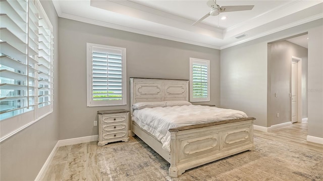 bedroom featuring a tray ceiling, baseboards, visible vents, and crown molding