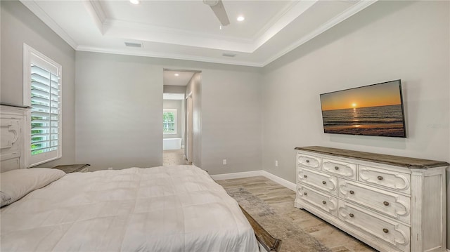 bedroom featuring a tray ceiling, multiple windows, visible vents, and crown molding