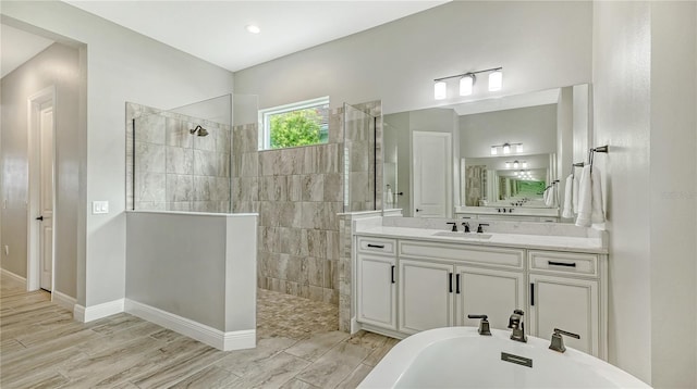 full bathroom with baseboards, a soaking tub, walk in shower, and vanity