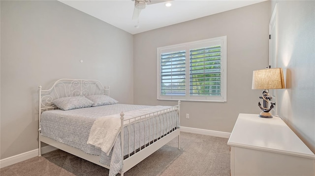 bedroom with light colored carpet, a ceiling fan, and baseboards