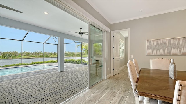 interior space with baseboards, wood tiled floor, a sunroom, a water view, and crown molding