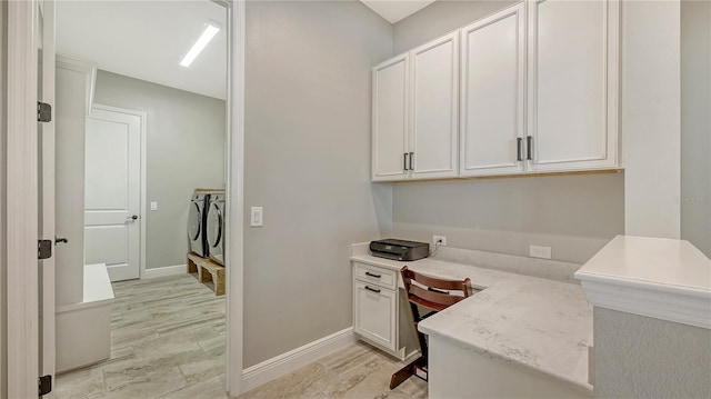 home office with light wood-type flooring, baseboards, and separate washer and dryer