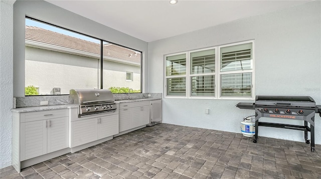 view of patio / terrace with area for grilling, a grill, and a sink