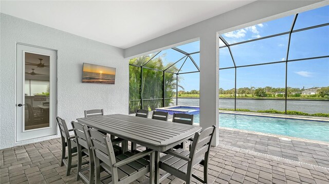 exterior space with glass enclosure, an in ground hot tub, an outdoor pool, and a water view