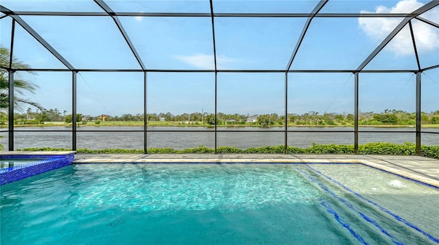 view of pool featuring a lanai, a water view, and a pool with connected hot tub