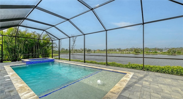 view of swimming pool featuring glass enclosure, a water view, a patio, and a pool with connected hot tub