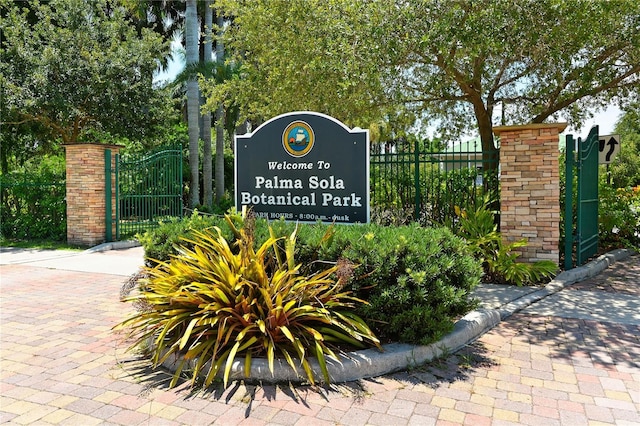 community sign featuring a gate and fence