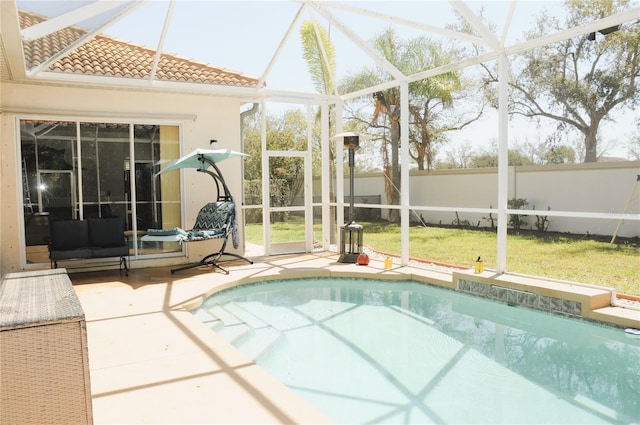 outdoor pool featuring a patio area, a lanai, a yard, and fence