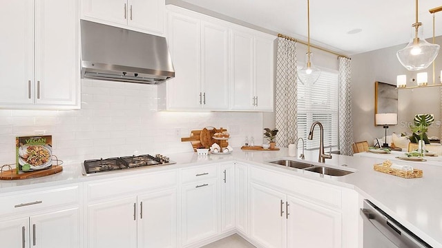 kitchen with stainless steel appliances, light countertops, white cabinetry, a sink, and under cabinet range hood