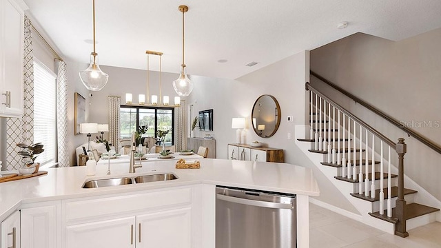 kitchen featuring light countertops, a sink, a peninsula, and stainless steel dishwasher