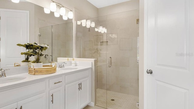 bathroom with double vanity, a stall shower, and a sink