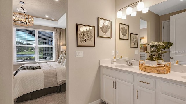 full bath featuring double vanity, an inviting chandelier, a sink, and baseboards