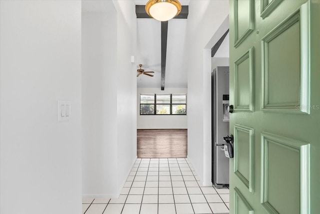 hall featuring lofted ceiling with beams and light tile patterned floors