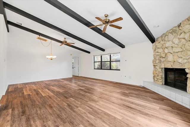 unfurnished living room with lofted ceiling with beams, a fireplace, wood finished floors, and ceiling fan with notable chandelier