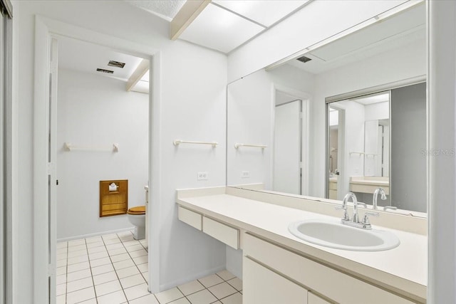 bathroom featuring baseboards, vanity, toilet, and tile patterned floors