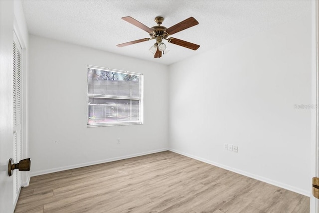 unfurnished bedroom with a textured ceiling, a closet, light wood-style flooring, and baseboards