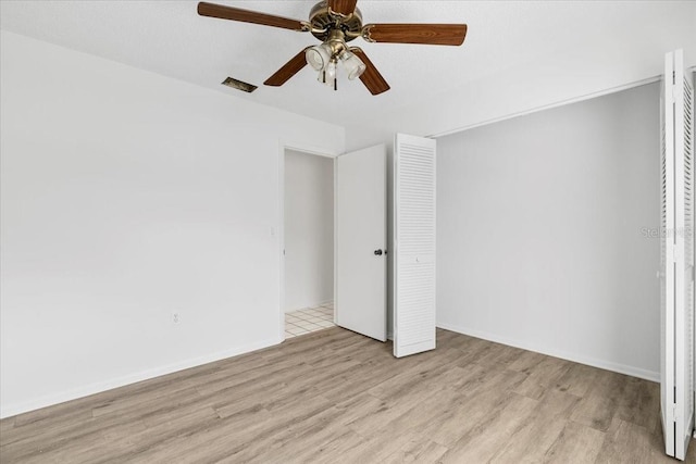 unfurnished bedroom featuring a closet, ceiling fan, baseboards, and wood finished floors