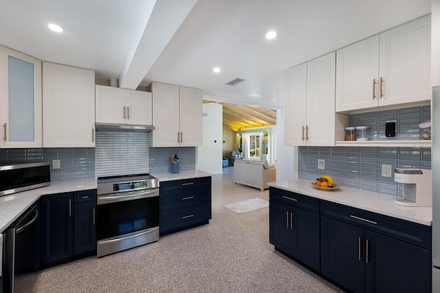 kitchen with visible vents, stainless steel appliances, white cabinets, under cabinet range hood, and tasteful backsplash