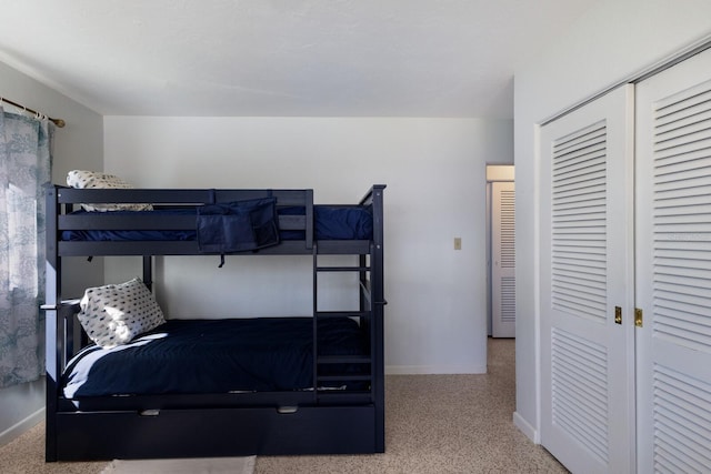 bedroom with speckled floor, baseboards, and a closet