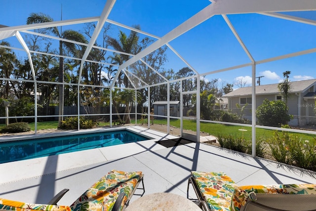 view of pool with glass enclosure and a patio