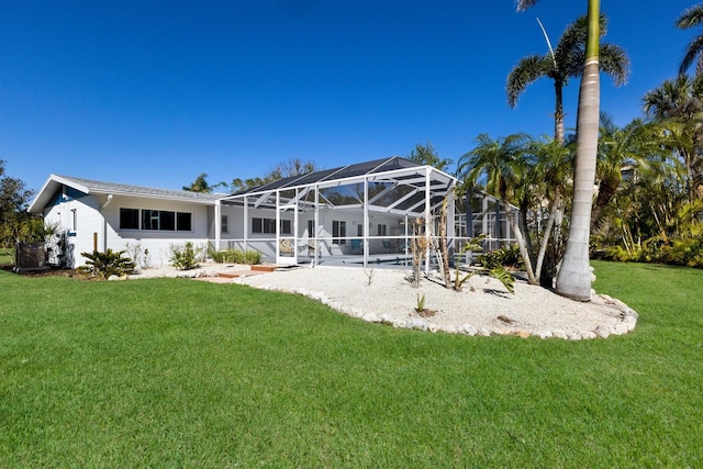 back of house featuring a lanai and a lawn