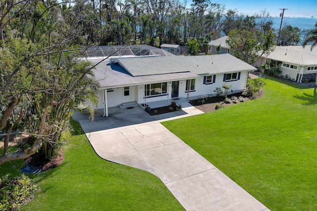 single story home with concrete driveway and a front lawn