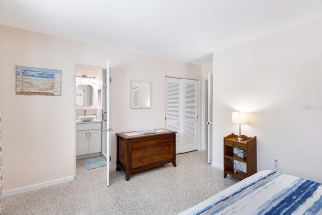 426 S Shore Dr, Sarasota, FL 34234 - bedroom featuring a closet, baseboards, ensuite bathroom, and a sink
