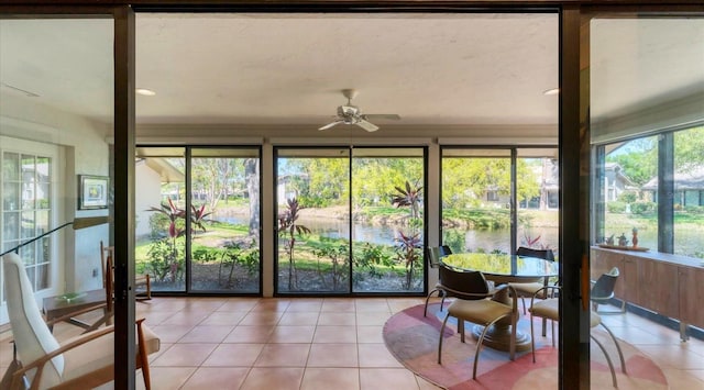 sunroom with a water view and a ceiling fan