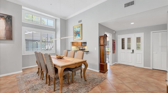 dining space featuring visible vents, baseboards, light tile patterned flooring, and ornamental molding