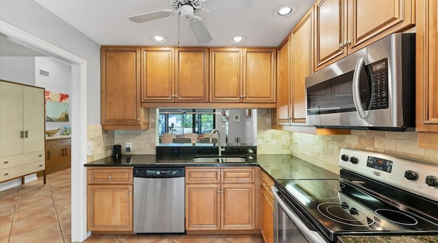 kitchen with light tile patterned floors, stainless steel appliances, ceiling fan, and a sink