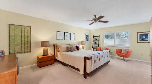 bedroom featuring baseboards, light colored carpet, and a ceiling fan