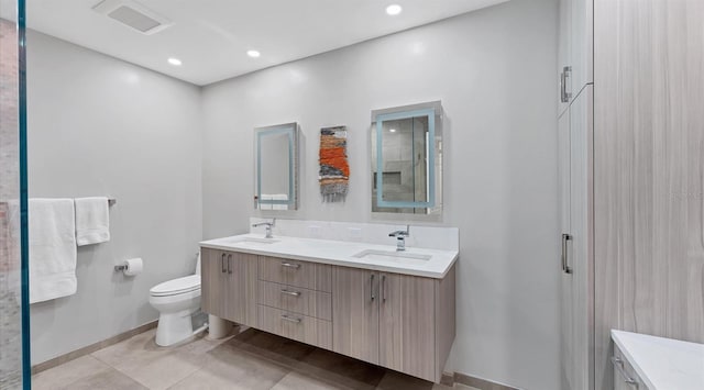 bathroom featuring double vanity, recessed lighting, toilet, and a sink