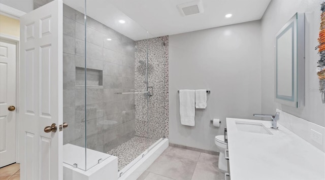 bathroom featuring vanity, tile patterned floors, toilet, and a stall shower