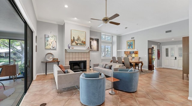 living area featuring a ceiling fan, visible vents, a wealth of natural light, and baseboards