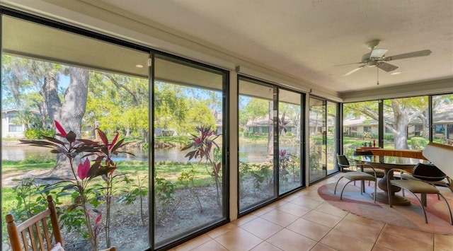 sunroom / solarium with a water view and ceiling fan