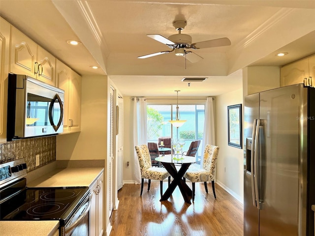 kitchen with visible vents, stainless steel appliances, light wood-style floors, and ornamental molding