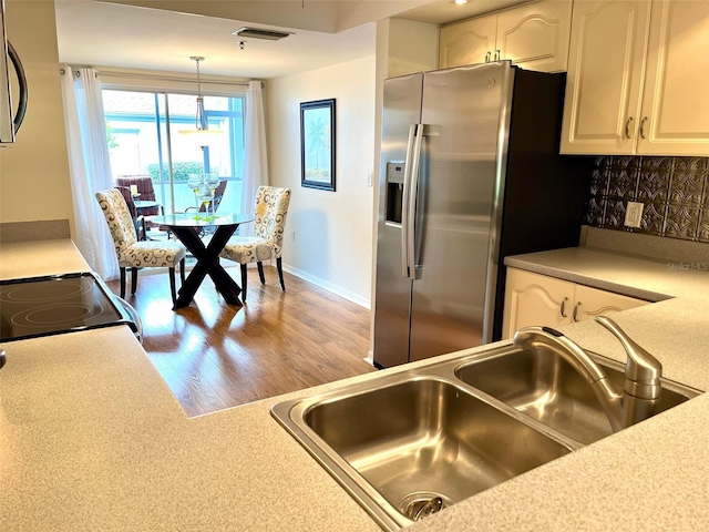 kitchen featuring decorative backsplash, white cabinets, stainless steel appliances, and a sink